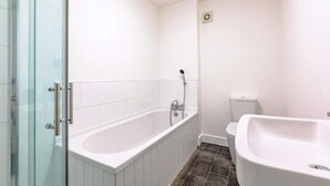 A bathroom with a glass shower enclosure, a bathtub, and a separate sink. - Beach Stay on the North Yorkshire Coast (Skinningrove)