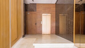 A modern elevator with a wooden finish and a marble wall. - Cozy Elegant Apartment - Rabat Center- Free Parking & AirC & Internet (Rabat)