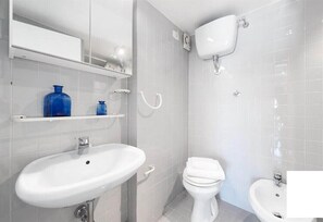 Een douche, een haardroger, een bidet, handdoeken