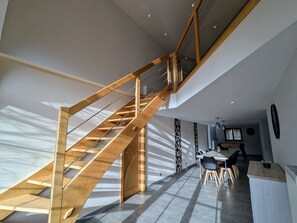 Un interior moderno con una escalera de madera, un comedor y una cocina.