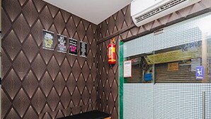A room with a patterned wall, a black countertop, and a tiled wall with a window. - Golden Sands Dormitory & Single AC Rooms (Mumbai)