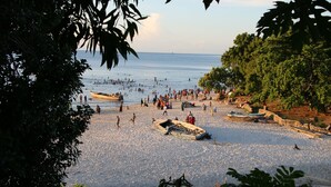 A beach with boats and people.