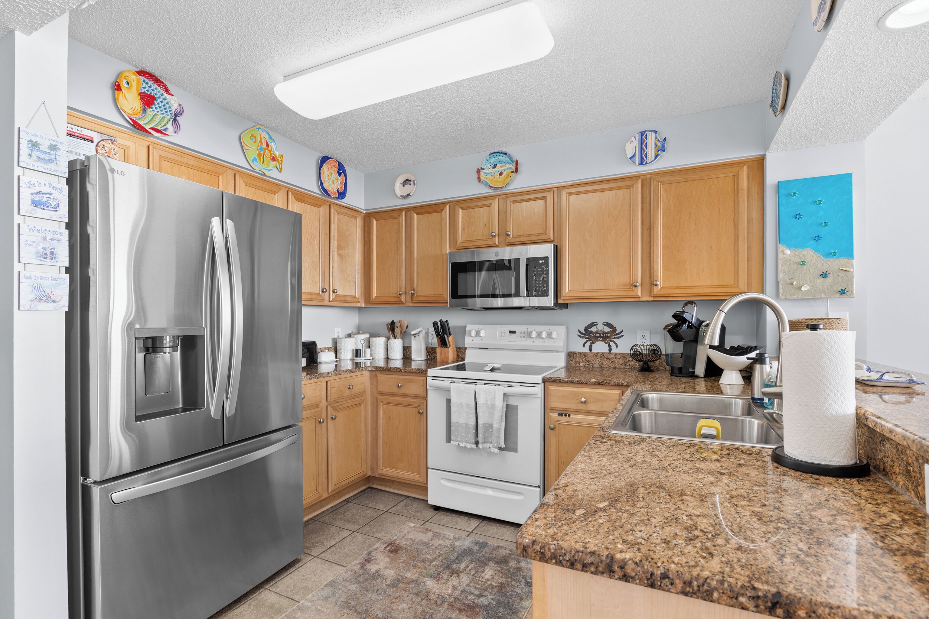 A kitchen with wooden cabinets, stainless steel appliances, and a granite countertop.