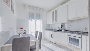 Una cocina moderna con armarios blancos, lavadora y estufa.