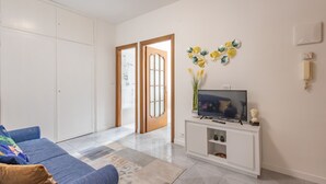 Una sala de estar con sofá, televisor y objetos decorativos.