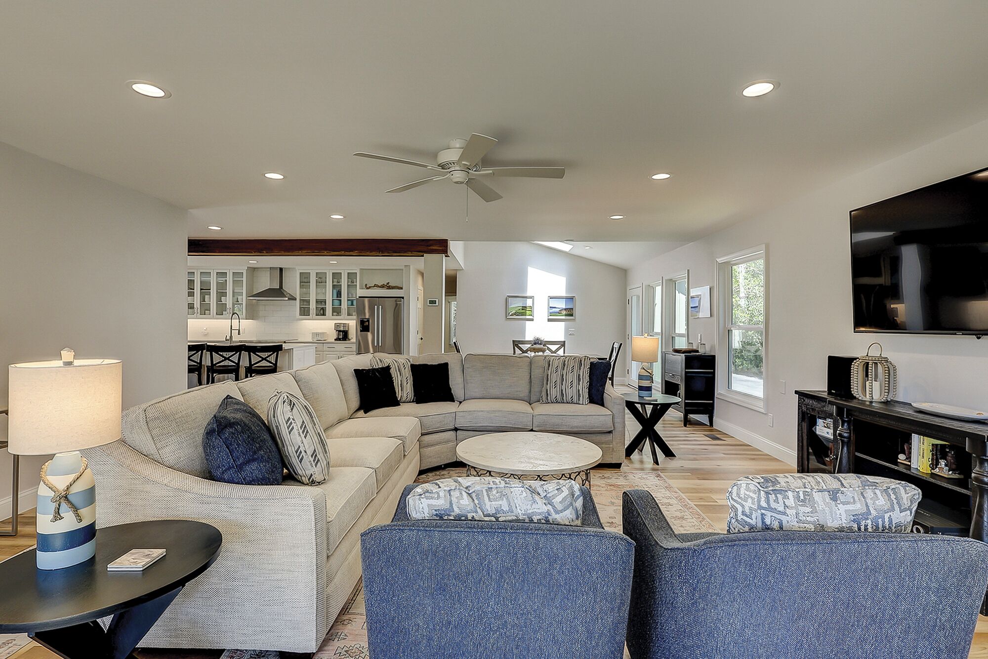 A modern living room with a sectional sofa, a round coffee table, and a TV.