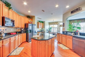 A modern kitchen with wooden cabinets, stainless steel appliances, and a central island. - 10 Mi to Dtwn Greensboro: Family Gem w/ Yard (Jamestown)