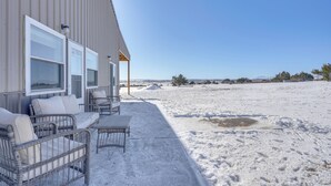 A covered outdoor seating area with wicker furniture and a view of a snowy landscape. - Mountain-view Hideaway w/ Patio in Pueblo! (Pueblo)