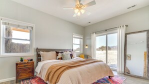 A bedroom with a bed, a nightstand, a window, and a view of the outdoors. - Mountain-view Hideaway w/ Patio in Pueblo! (Pueblo)