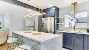 A modern kitchen with marble countertops, stainless steel appliances, and a central island. - 6 Mi to Spectrum Center: Spacious Getaway w/ Deck (Charlotte)