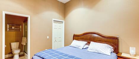 A bedroom with a wooden bed, a nightstand, and a ceiling fan.