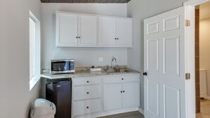 A compact kitchen with white cabinets, a microwave, a sink, and a dishwasher. - 6 Mi to Frazier Mountain: Cozy Studio Retreat (Frazier Park)