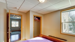 Un dormitorio con una cama, una ventana y una puerta que da a otra habitación.