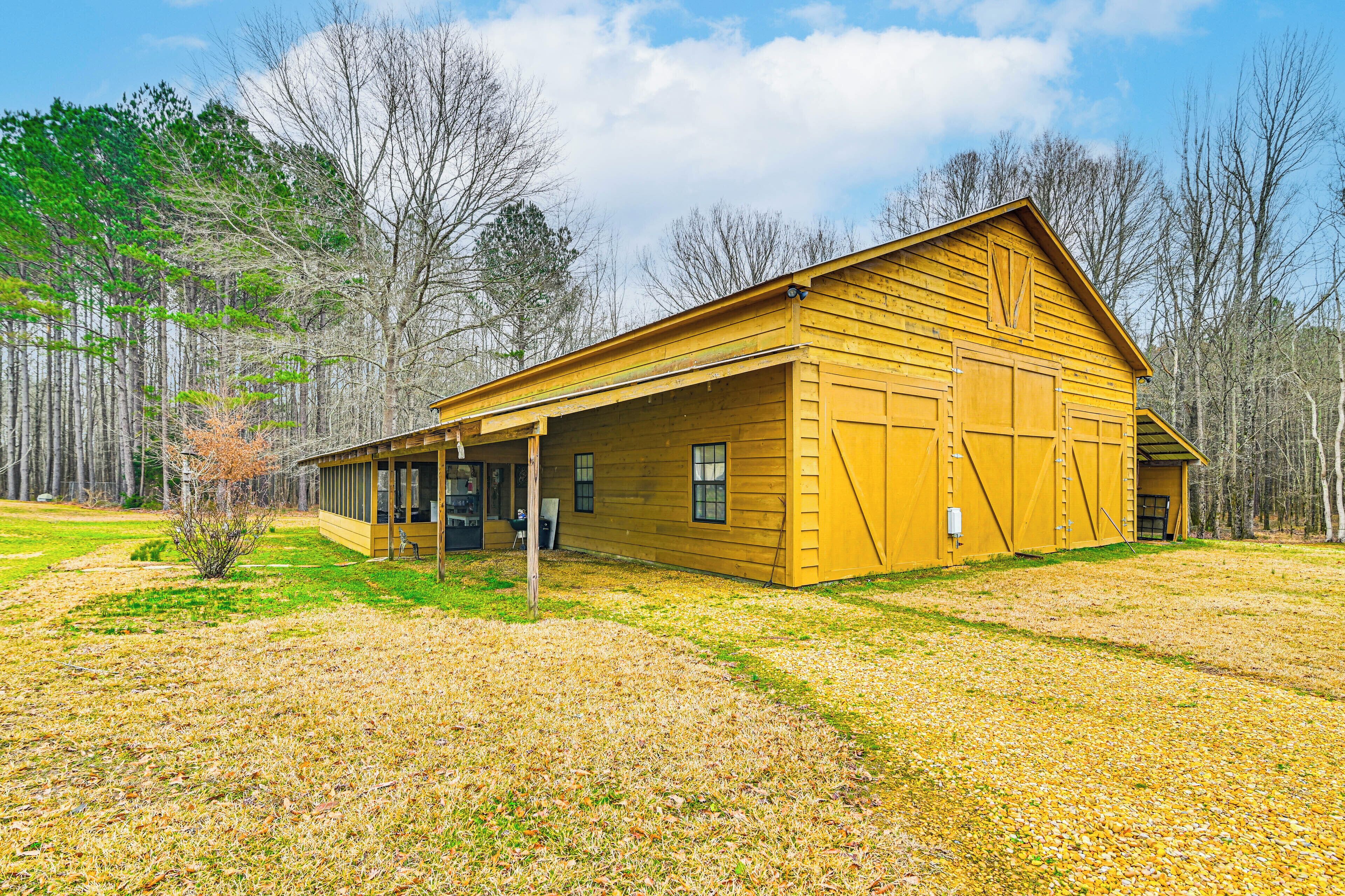 A yellow wooden building with a covered porch and a garage.
