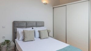 Ein Schlafzimmer mit Bett, Nachttisch und Kleiderschrank.