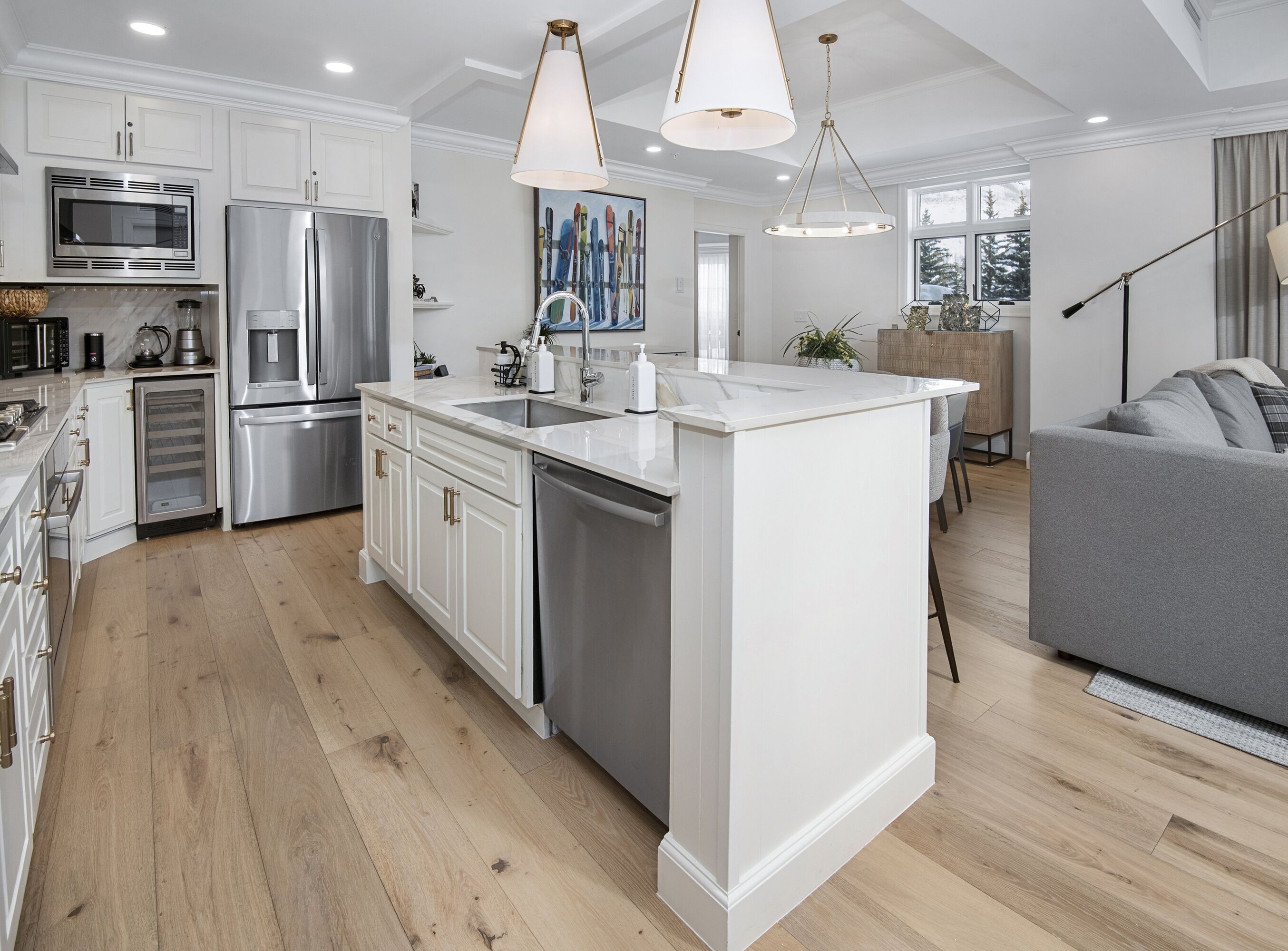 A modern kitchen with white cabinetry, stainless steel appliances, and a central island.