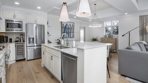 A modern kitchen with white cabinetry, stainless steel appliances, and a central island. - Ritz Carlton Vail #314 3 Bedroom Condo (Vail)