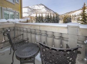 Ein Balkon mit Blick auf schneebedeckte Berge und Bäume.