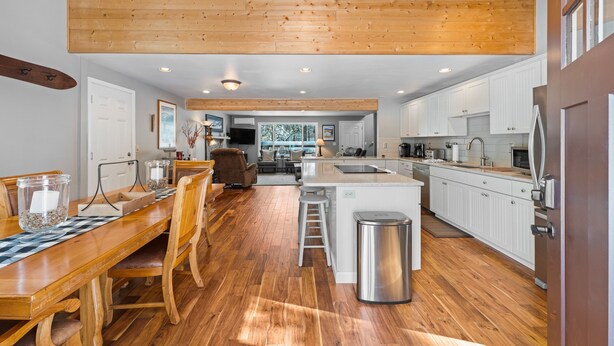 A spacious kitchen with wooden flooring, white cabinetry, and a central island. - 8 East Butte Ln 3 Bedroom Home (Bend)