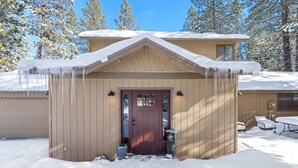 A two-story house with a snow-covered roof and icicles hanging from the eaves. - 8 East Butte Ln 3 Bedroom Home (Bend)