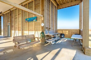A wooden cabin with a bench, a table, and a hanging sign. - Perfectly Happy 4 Bedroom Home (Port Bolivar)