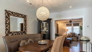 A dining area with a dark wood table, cushioned bench, and a decorative mirror.