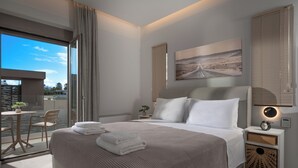 A modern hotel room with a large bed, a small table with chairs, a balcony, and a painting on the wall. - Magian Luxury Apartments (Malevizi)