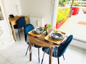 Enjoy meals for two at a beautifully set table with a vase and a rose.