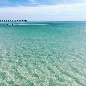 Una vista despejada de la costa con un muelle que se adentra en el mar.