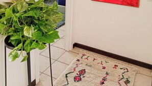 A hallway with a potted plant, a colorful abstract painting, and a patterned rug. - Spacious apartment in historic country residence, between Perugia and Assisi (Perugia)