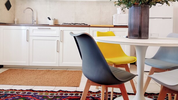 A modern kitchen with white cabinets, a stove, and a dining table with chairs. - Spacious apartment in historic country residence, between Perugia and Assisi (Perugia)