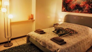 A hotel room with a bed, a nightstand, a lamp, and a painting on the wall. - Spacious apartment in historic country residence, between Perugia and Assisi (Perugia)