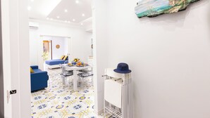 A modern interior with a dining area, a blue sofa, and a patterned floor. - Marescala Vacation - Casa Cicirusso, elegant apartment in Sorrento town center (Sorrento)