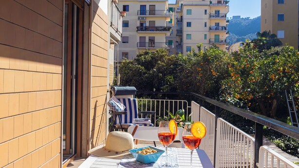 A balcony with a table set for two, a chair, and a sun lounger. - Marescala Vacation - Casa Cicirusso, elegant apartment in Sorrento town center (Sorrento)
