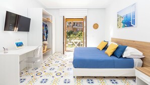 A bedroom with a bed, a desk, a chair, and a TV. - Marescala Vacation - Casa Cicirusso, elegant apartment in Sorrento town center (Sorrento)