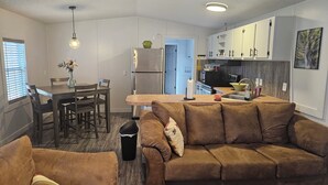 A compact living space with a kitchenette, a dining area, and a sofa.