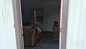 A doorway leading into a room with a bed, a desk, and a window.