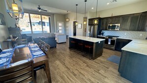 A modern kitchen with a central island, wooden flooring, and pendant lighting. - Scenic Escape in Kanab | Pet-Friendly | Community Pool & Hot Tub (Kanab)