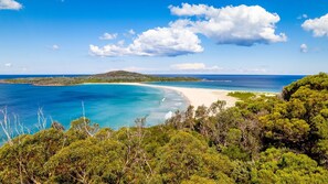 A coastal landscape with a beach, clear blue waters, and lush greenery. - Amanda Court 14, 1-5 Weatherly Close - 250 metres from Shoal Bay Beach (Nelson Bay)