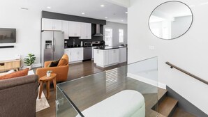 A modern apartment with a living room, kitchen, and staircase. - Bright & Modern Apt | Steps to Lake, Train, Food (Chicago)