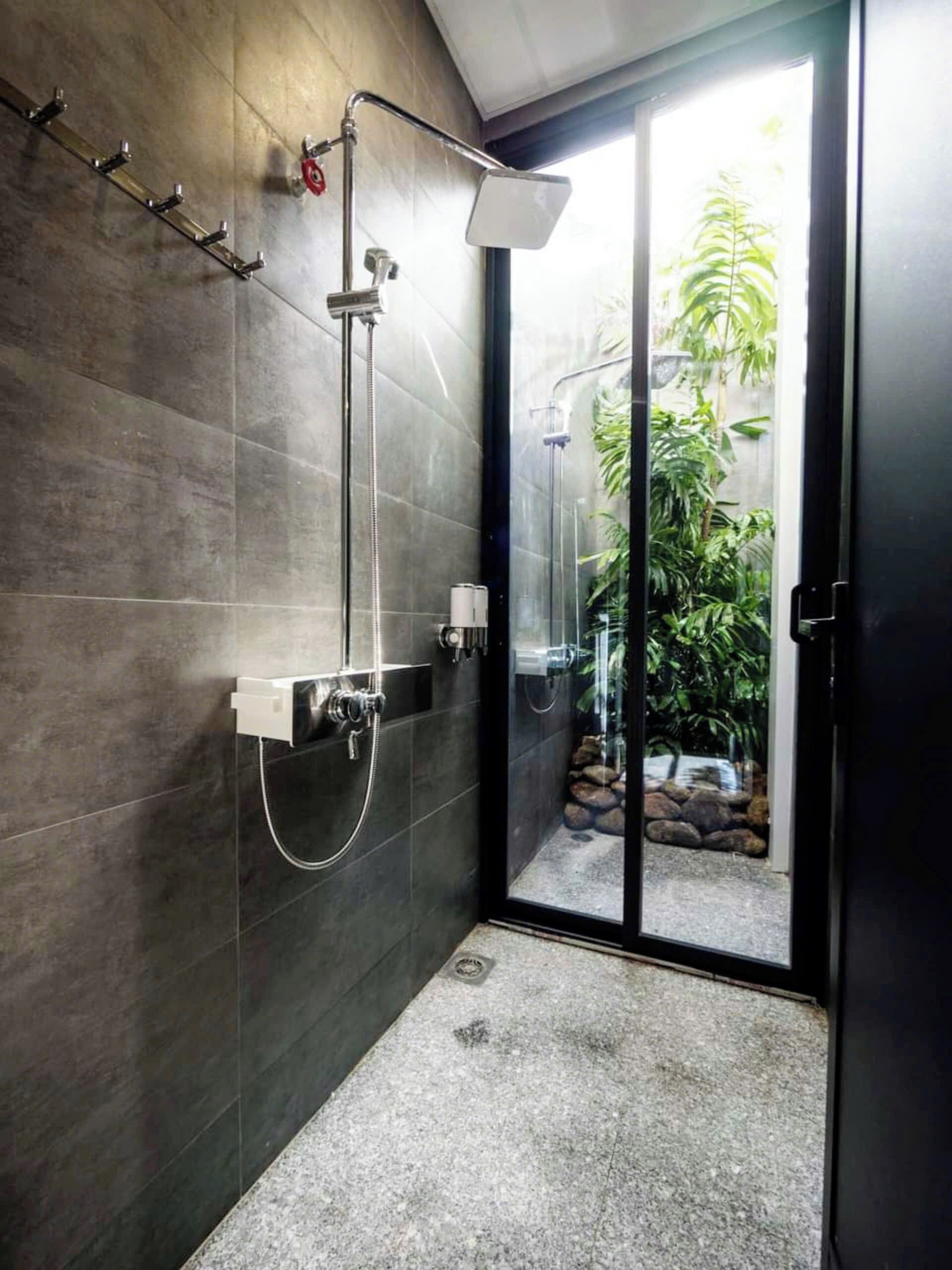 Een moderne badkamer met een glazen douchecabine, een ingebouwd wastafelmeubel en een handdoekhouder.