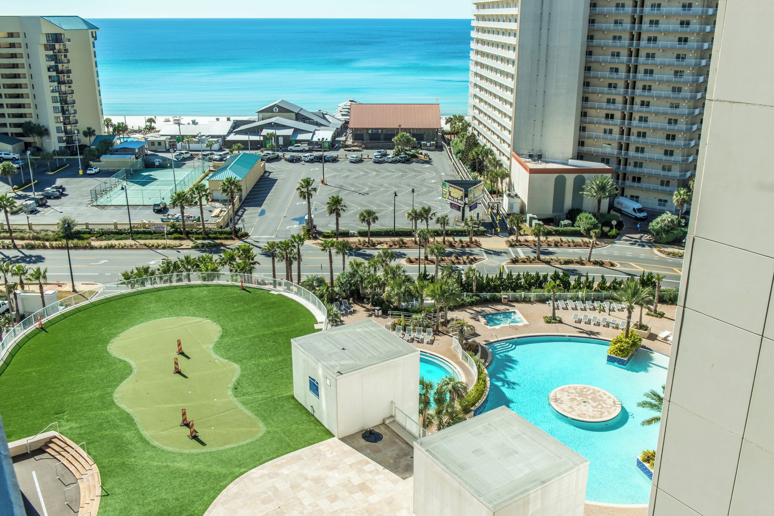 Ein Resort mit Pool, Tennisplatz und Meerblick.