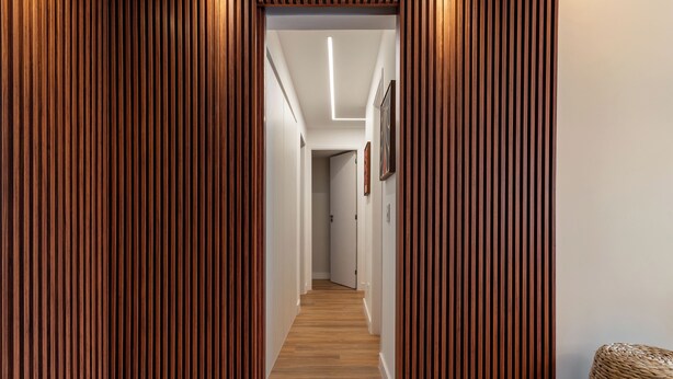 Ein Korridor mit Holzvertäfelung und einer Leuchte an der Decke.