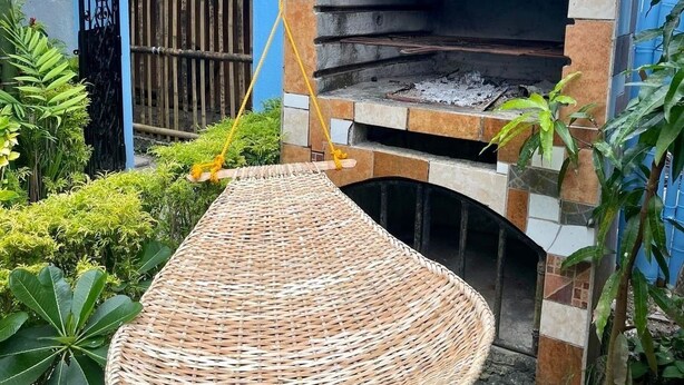 A traditional brick oven with a thatched roof, a wicker hammock, and a sign reading "Ocean Breeze Inn". - Ocean Breeze Inn Boracay (Boracay Island)