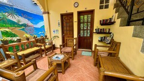 A cozy room with wooden furniture, a mural, and a bookshelf. - Ocean Breeze Inn Boracay (Boracay Island)