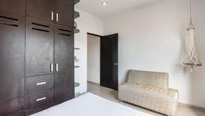 A modern bedroom with a large wardrobe, a bed, and a hanging light fixture. - Beautiful complete 2 bedroom apartment, Tulum Centro! Aluxe (Tulum)