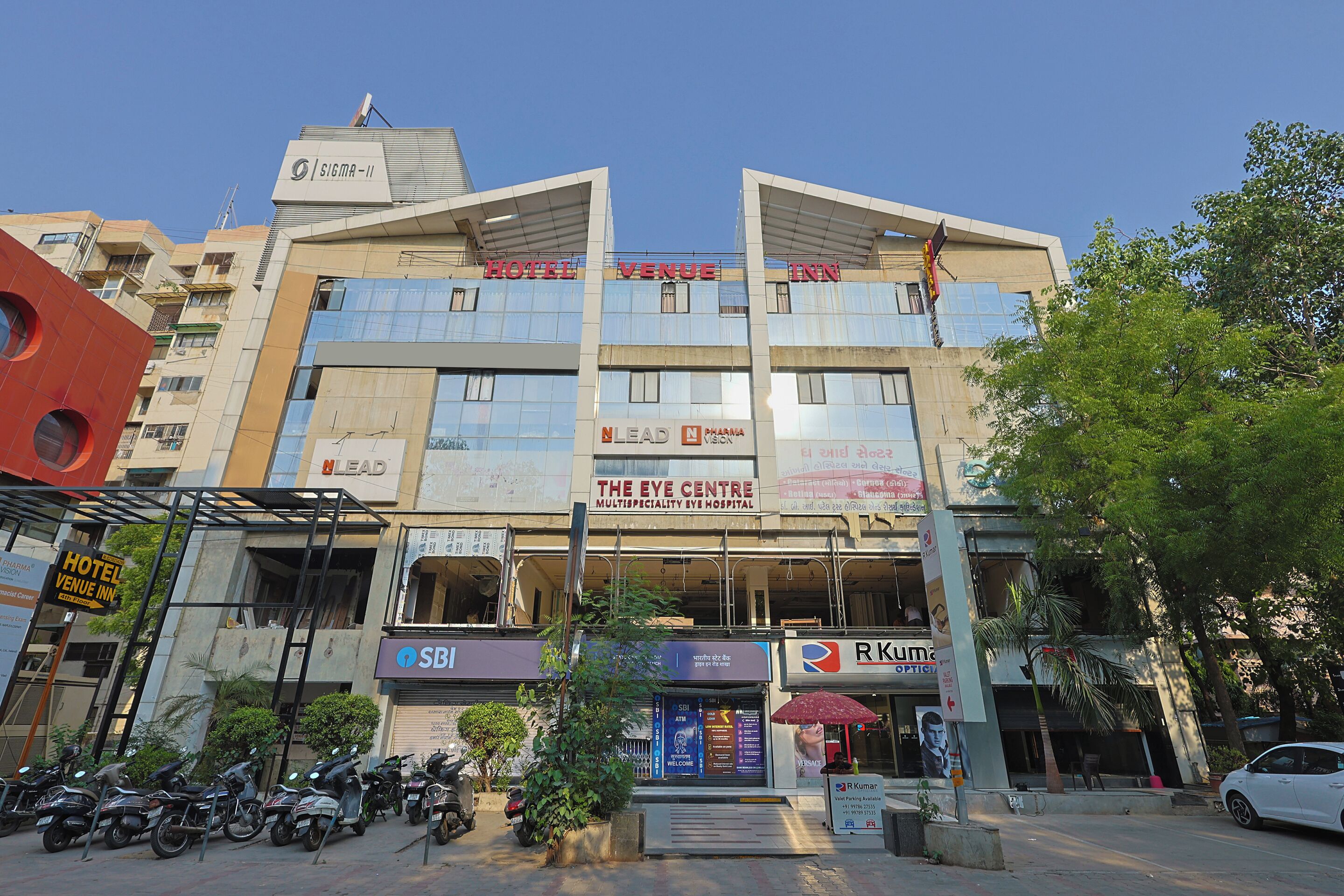 A multi-story building with signs for 'Hotel Venue Inn' and 'The Eye Centre Multispeciality Eye Hospital'.