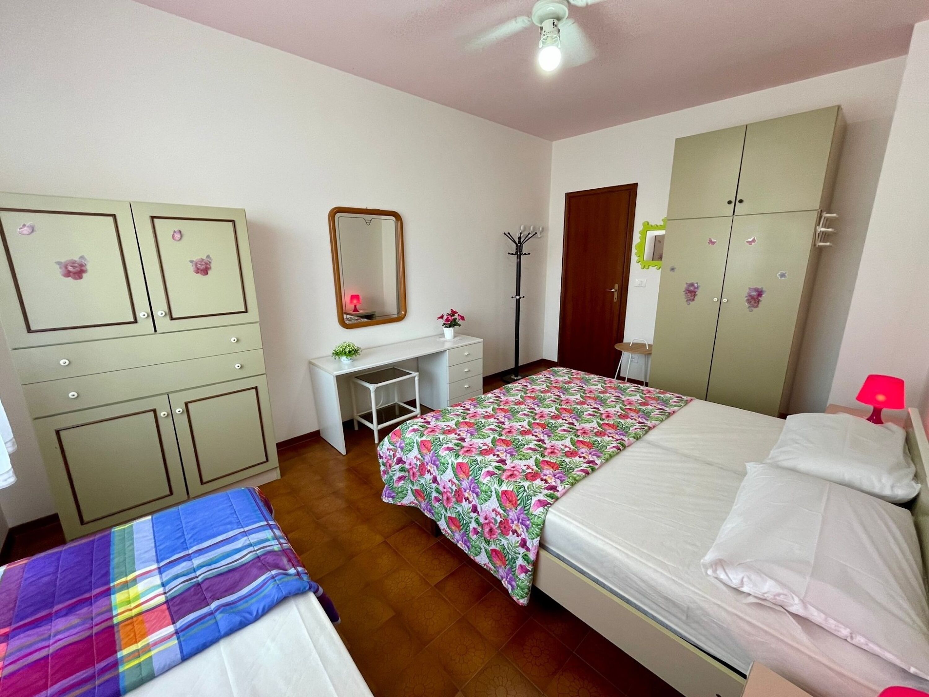 A bedroom with a bed, a desk, a wardrobe, and a chair.