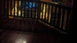 Un intérieur en bois avec un plafond en pente, un tableau représentant un élan et un escalier menant à un balcon.