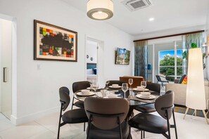 A dining area with a round table set for four, surrounded by black chairs. - 2BR Condo w/ Pool-View Balcony near Palm Beach (Noord)